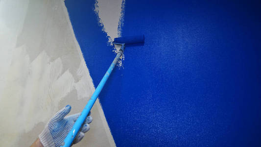 滚子把墙上的油漆蓝。