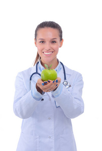 微笑着一个绿色的苹果的女医生。女医生