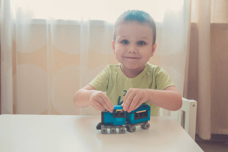 男孩玩与彩色砖近肖像建设者火车