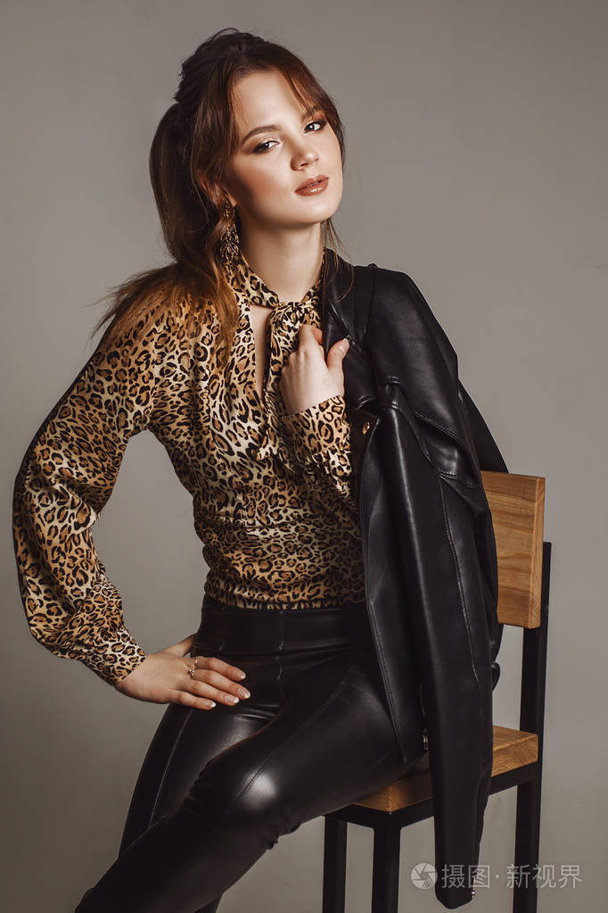 性感的年轻女孩坐在酒吧凳子上