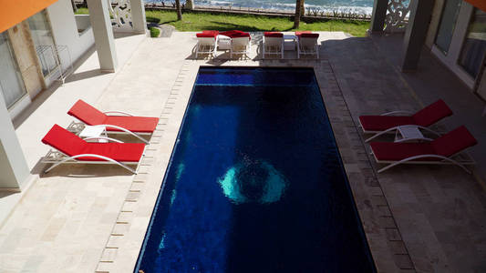 豪华酒店，游泳池，阳光床，棕榈树，海边。 带游泳池的热带度假胜地。 旅行概念。