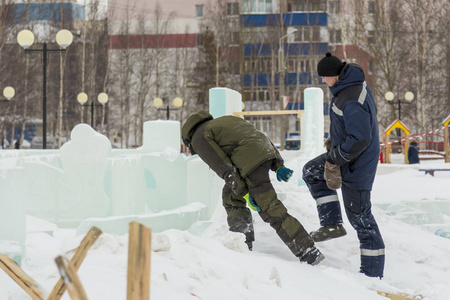 两个工人在冰城里克服了雪堆