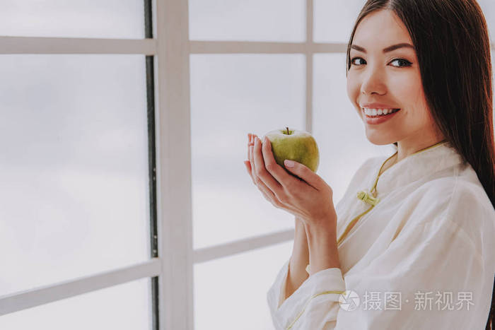 微笑的年轻女士抱着新鲜的水果