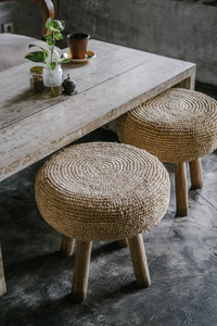 天然稻草圆垫椅与木腿灰色混凝土地板。 密切注意细节。 极简阁楼咖啡厅，家居室内设计