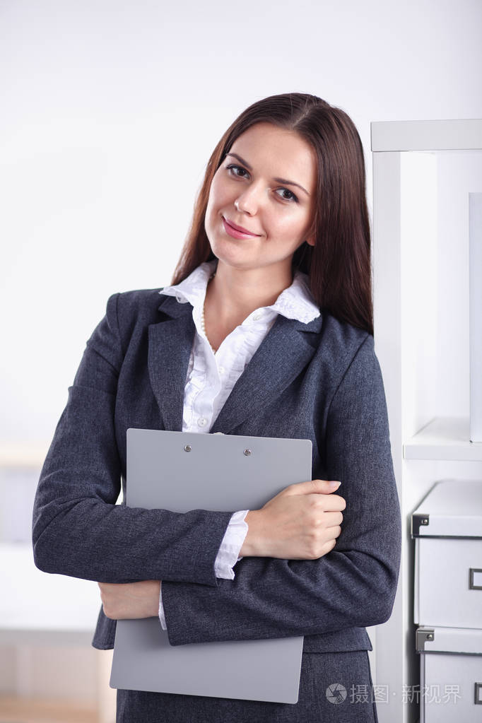 站在办公室的双臂交叉的商界女强人的肖像