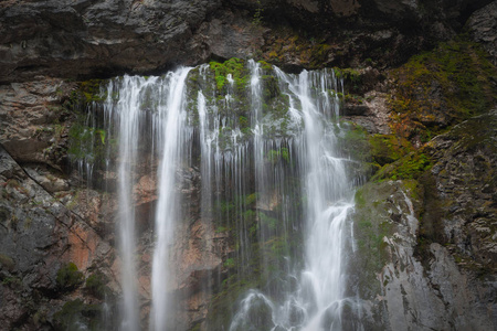 水从瀑布中流出，沿着岩石向近处流淌
