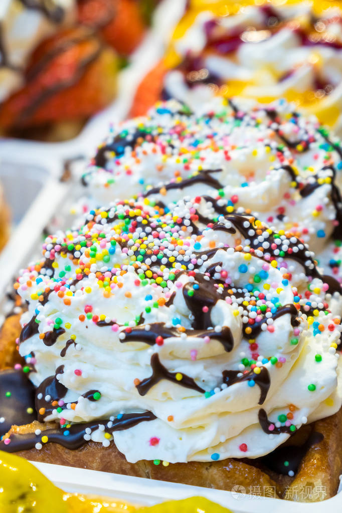 五颜六色的蛋糕甜甜点和鲜奶油在街头食品市场.