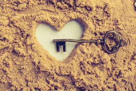 复古风格的钥匙和棕色沙子做的心形