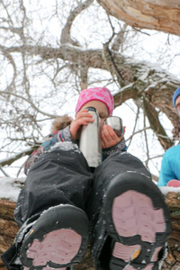 年轻的女责骂男子与小女孩有乐趣在雪林在冬天