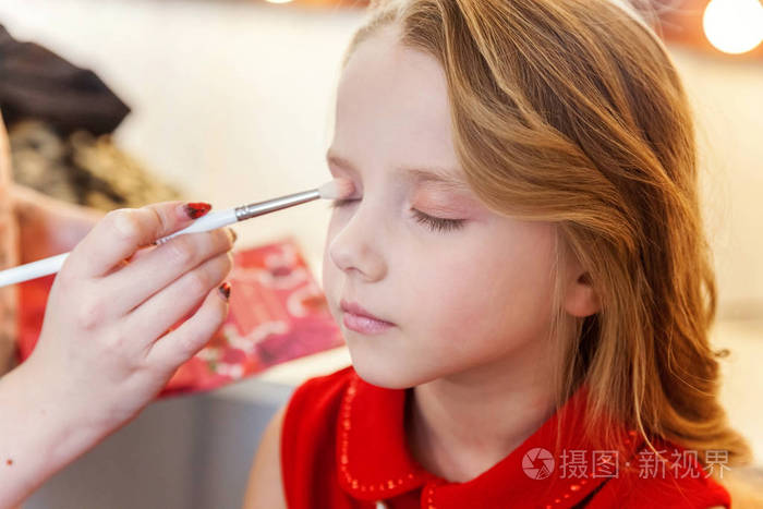 女孩模特涂上眼影专业化妆由艺术家申请在过程中弥补细节时尚儿童美容