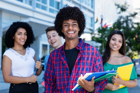 美国黑人嬉皮士学生与一群国际学生在城市户外嬉笑