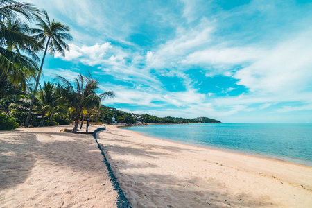 美丽的热带海滩，大海和沙滩，蓝天和白云上有椰子棕榈树，供旅行和度假使用