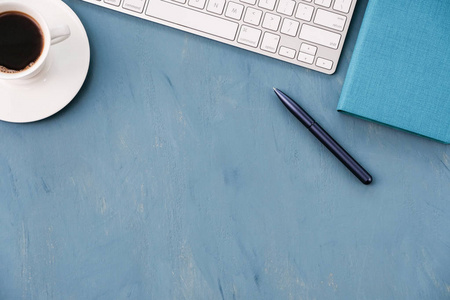 商业背景键盘蓝色钢笔和蓝色桌面上的笔记本。