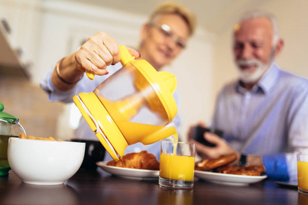 快乐有爱的老夫妇在厨房里享用早餐准备健康食品