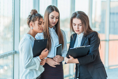 友好的购物者友好的三国商人小组站在办公室里, 拿着文件, 研究财务