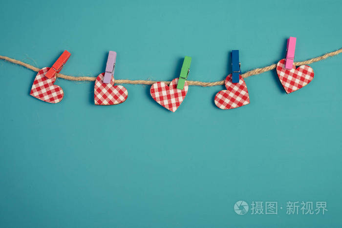 爱的心挂在蓝色背景上的绳子上图像