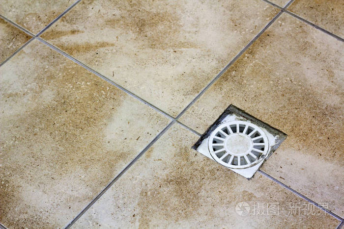 厨房浴室或地下室陶瓷瓷砖旧地板的排水孔几何抽象米色背景