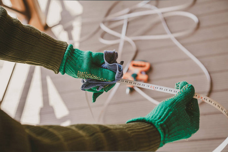 爱护工具..双手戴绿色手套，用长着粗布的金属胶带擦拭