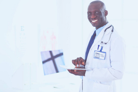 男性黑人医生与平板电脑站在医院