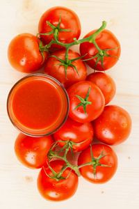 杯番茄汁与西红柿在木制背景下健康的生活方式概念。 从上面看。