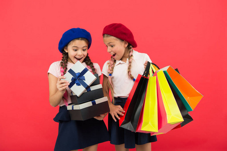 购物理念。孩子可爱的小女孩在购物之旅。最优惠的价格。现在购买。参观购物中心。孩子们的女孩拿着一堆购物袋或生日礼物包。梦想成真。快