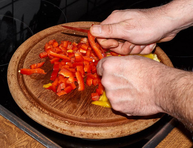 在木板上用刀子切出的黄色和红色辣椒