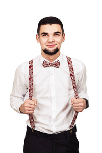 时尚的年轻胡须的家伙在衬衫, 裤子和吊带摆在白色的背景