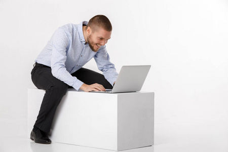 年轻英俊的男人在衬衫和领带使用笔记本电脑
