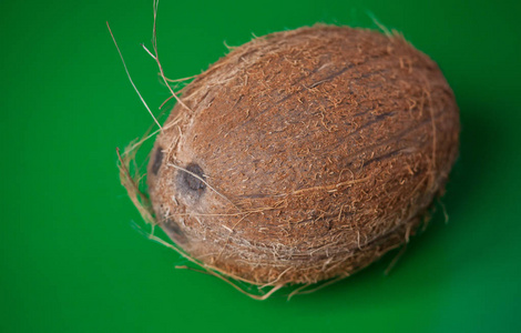 在绿色背景上关闭一个异国情调和新鲜的椰子。 椰子的新鲜成熟有机果。