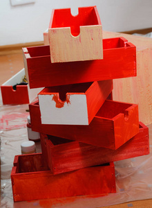 六个新油漆的红色木箱和几个油漆罐站在地板上
