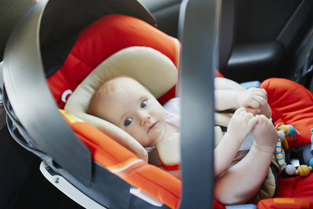可爱的女婴在现代汽车座椅上。 开车旅行的小孩。 道路上的儿童安全。 和一个婴儿一起旅行。