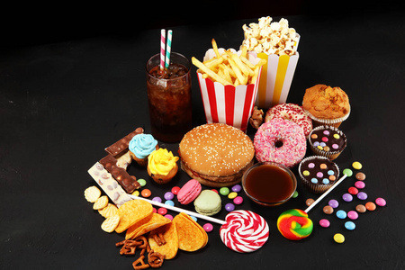 对身材,皮肤,心脏和牙齿有害的食物. 各种快餐碳水化合物食品.照片