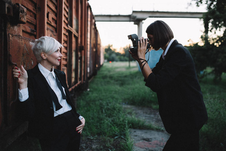 女摄影师在火车站拍摄女青年西装革履的照片