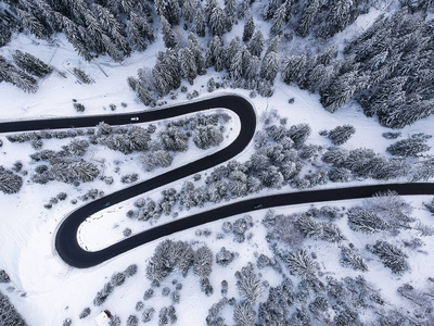 从美丽的曲线路上看，在冬天充满雪的森林中间。