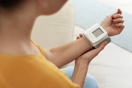 妇女检查血压与血压计在家里特写。 心脏学概念