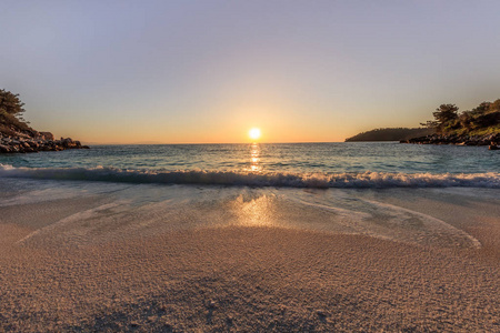 太阳升起在大理石海滩萨拉海滩，塔索斯群岛，希腊。希腊最美丽的白色海滩