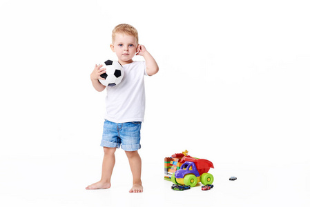 小可爱小男孩3岁，足球迷穿白色t恤玩足球孤立在白色背景上。生活方式的概念。文本复制空间