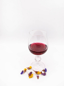 一杯红酒，在白色背景上分离出一些干花