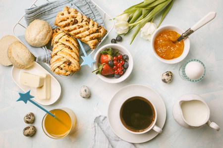 早餐桌。 咖啡鸡蛋牛奶包子果汁和果酱。 蓝色背景俯视食物平躺。