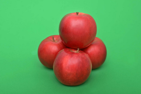 绿色背景上的四个红苹果