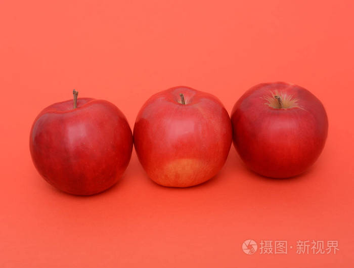 红色背景上的三个红苹果