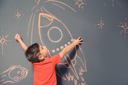 可爱的小孩玩粉笔火箭画灰色背景