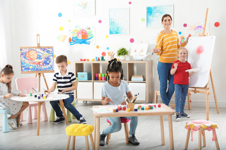 儿童与女教师在室内绘画课