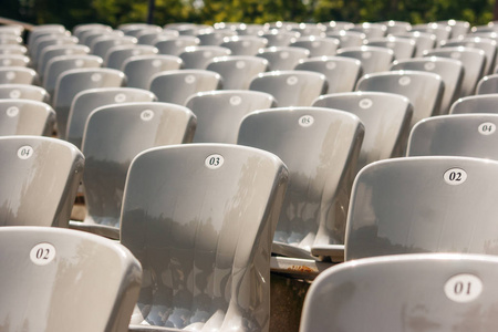 在阳光明媚的夏日，体育场室外的一排排塑料座椅