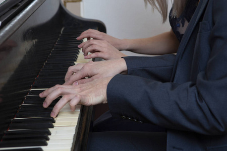 特写音乐家用手在钢琴键盘上弹钢琴。 抽象的音乐背景