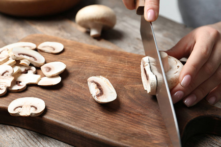 年轻女子在木板上剪鲜香葵蘑菇的特写镜头