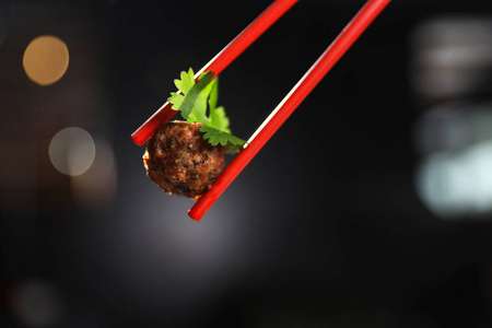 筷子与肉球在黑暗的背景特写。 文本空间