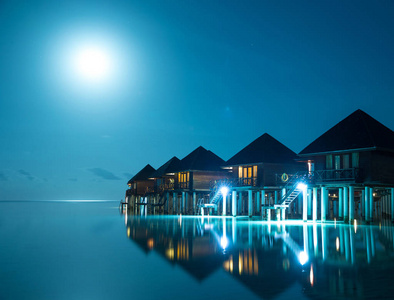 日落马尔代夫岛豪华水上别墅度假村和木墩。 美丽的天空和云彩，海滩背景，为暑假假期和概念