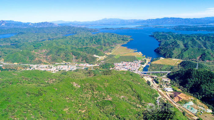 背景上有水库的山的鸟瞰图山顶有美丽的蓝天和绿色的森林自然保护区