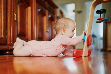 女婴在地板上玩玩具。 快乐健康的小孩在家